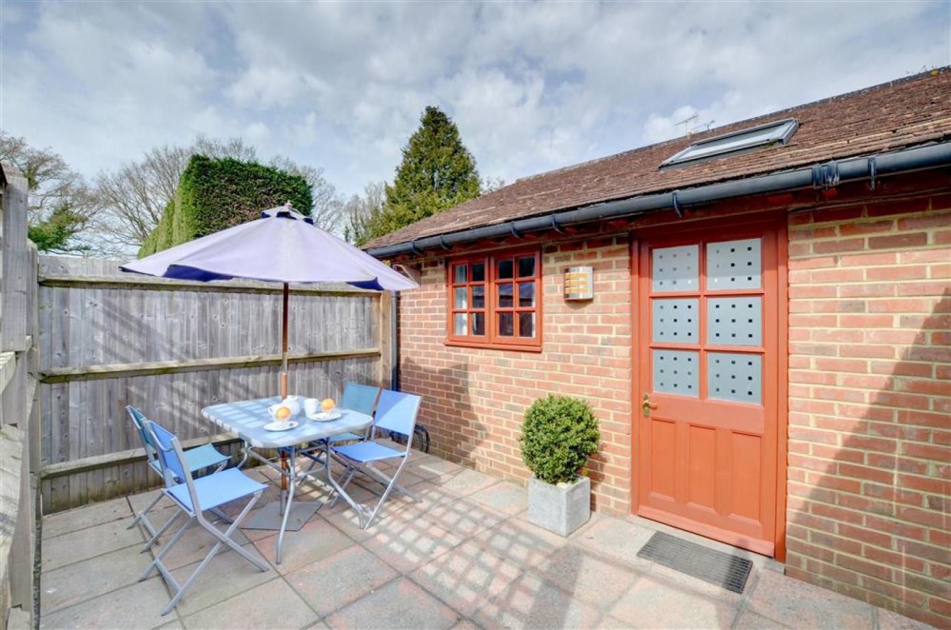 The patio is shown outside the Cranbrook apartments with table and chairs for accomodation in Kent..